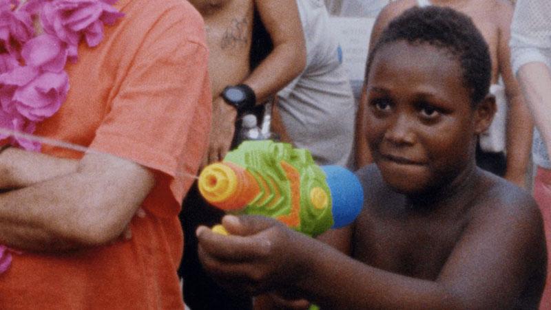 Photo film Or Rio continua lindo de Felipe Casanova. Un enfant joue avec un pistolet à eau.