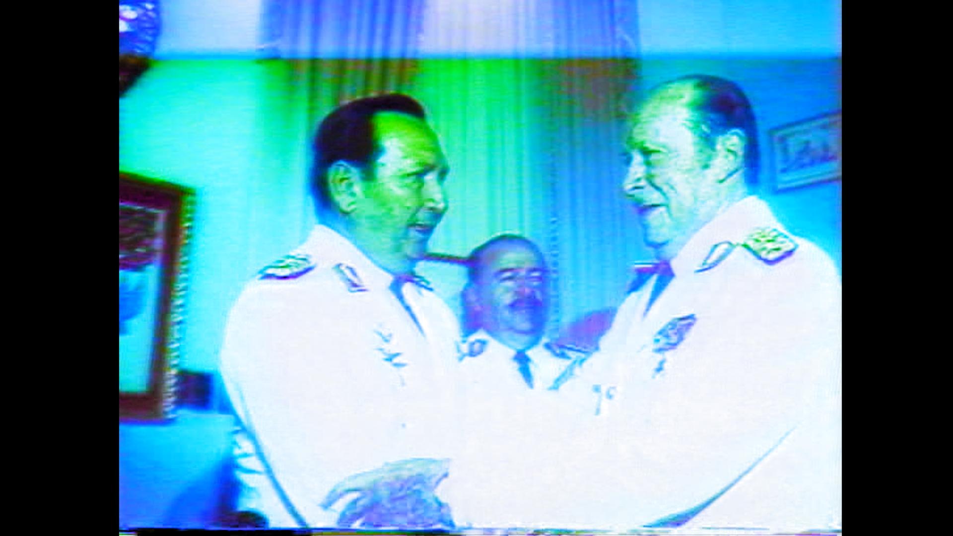 Deux hommes en costumes militaires blancs se serrent les mains