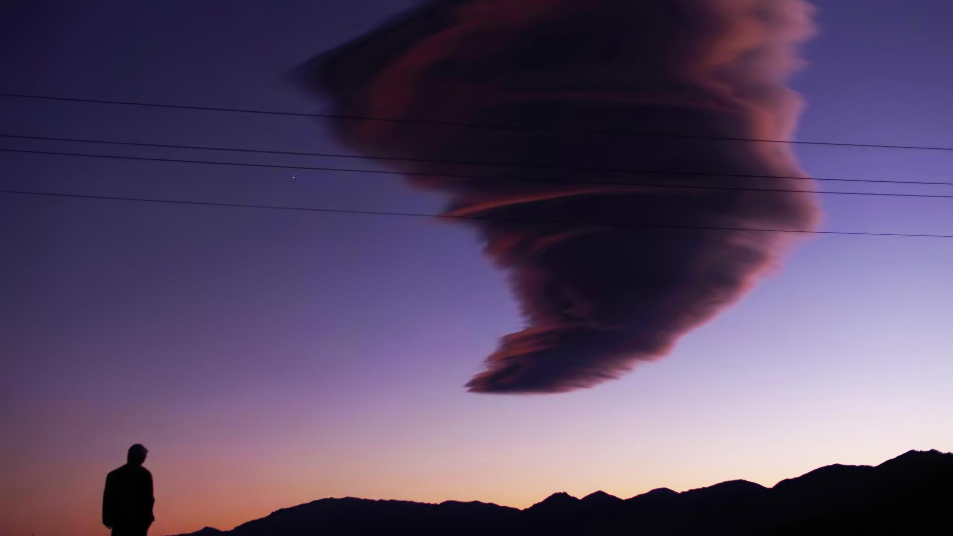 Ciel violet, silhouette d'homme et nuage tournoyant